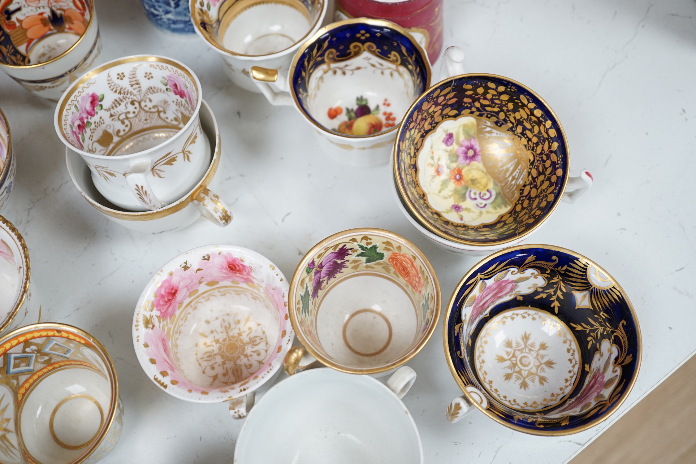 A group of Regency and Victorian porcelain tea, coffee cups and saucers, Newhall, Chamberlains, Coalport, etc.